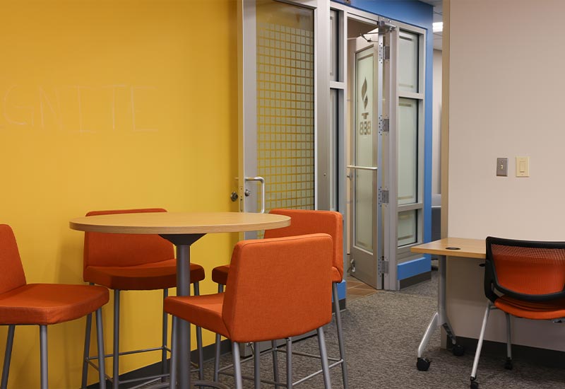 Lounge sitting area with tables and chairs | ignite Sparked by BBB Central Virginia