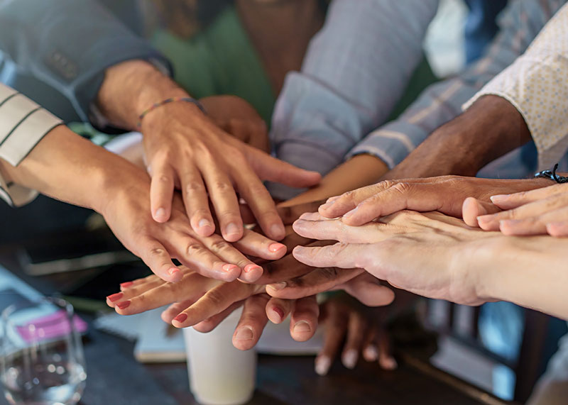 Professionals putting hands together in collaboration